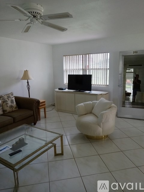 A living room with a couch, chair, and television.