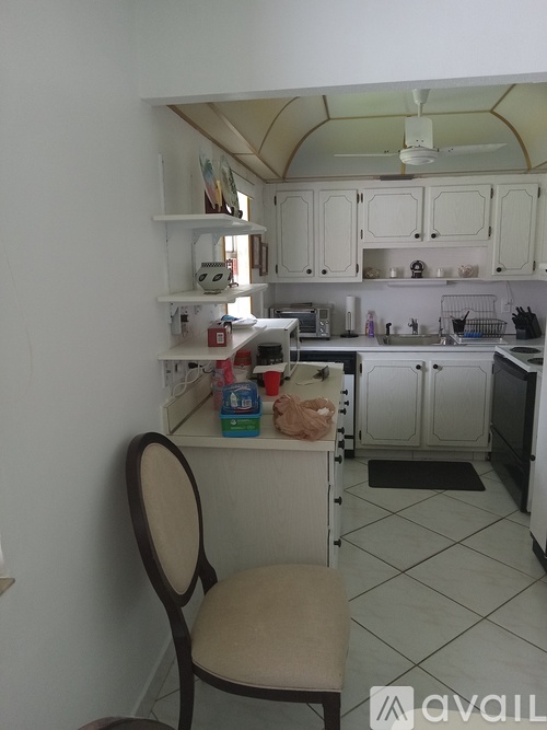 A kitchen with a chair and a fan.