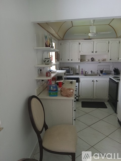 A kitchen with a chair and a fan.