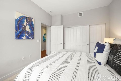 A bedroom with a large bed and a painting on the wall.