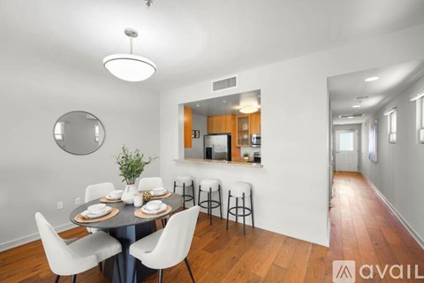 A dining room with a table set for four and a bar area in the background.