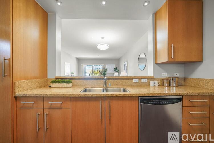 A kitchen with wooden cabinets and a black dishwasher.