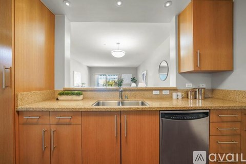 A kitchen with wooden cabinets and a black dishwasher.