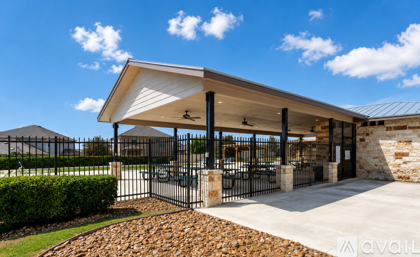 A modern building with a black gate and a stone pillar.
