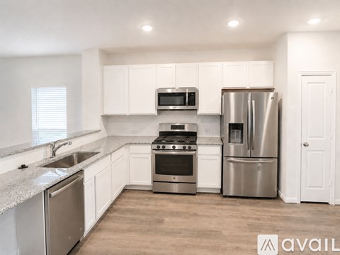 A modern kitchen with stainless steel appliances and white cabinets.