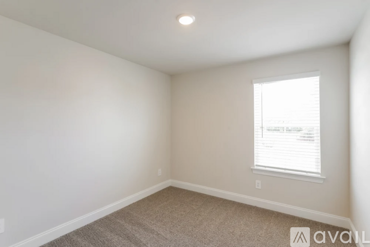 A room with a window and carpeted floor.