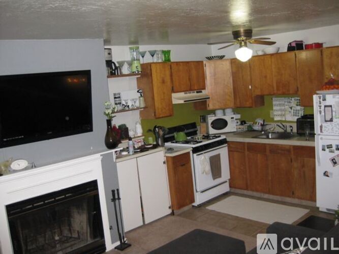 A kitchen with a white fridge, white stove, and white cabinets.