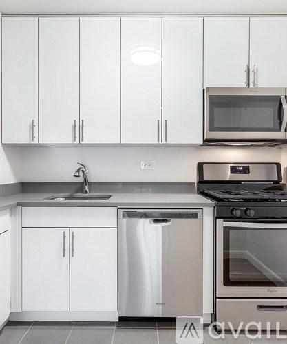 A kitchen with white cabinets and a stainless steel dishwasher.