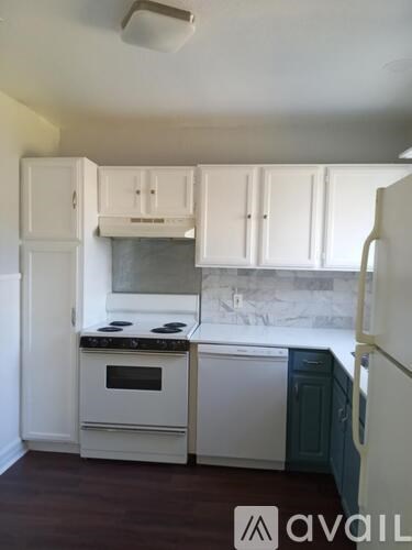 A kitchen with white cabinets and a stove top oven.