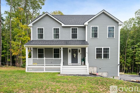 A two-story house with a front porch is for sale.