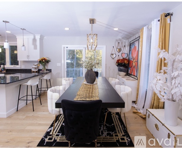 A black and white dining room with a long table and chairs.