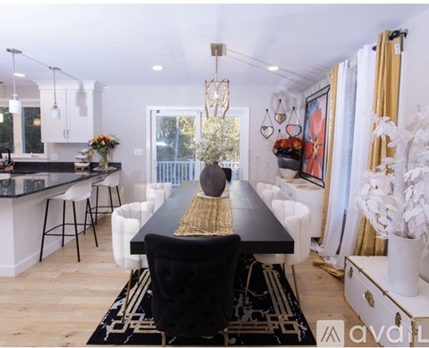 A black and white dining room with a long table and chairs.