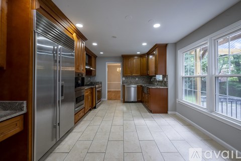 A kitchen with wooden cabinets and a stainless steel refrigerator.