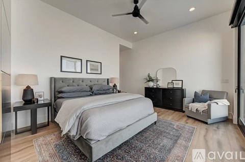 A bedroom with a large bed and a ceiling fan.