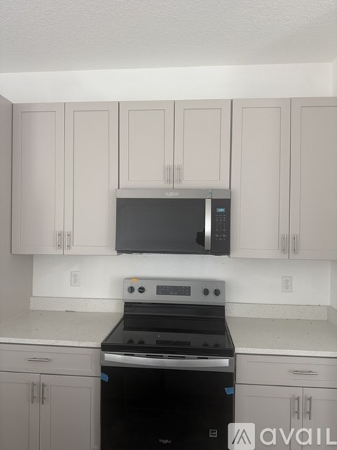 A kitchen with white cabinets and a black stove top oven.