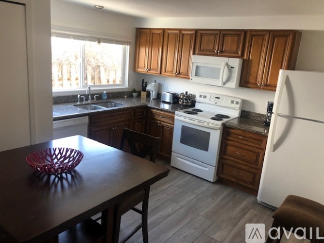 A kitchen with a white stove and wooden cabinets.