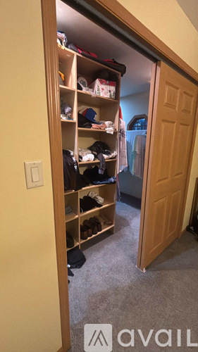 A small closet with a lot of clothes and shoes.