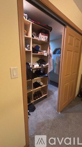 A small closet with a lot of clothes and shoes.