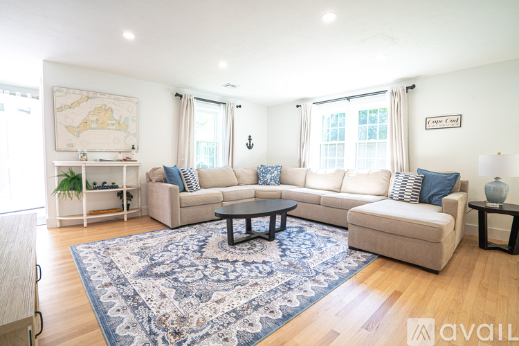 A living room with a rug, couches, and a map on the wall.