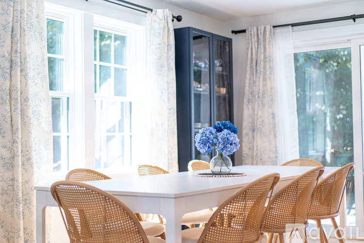 A dining room with a white table and chairs.