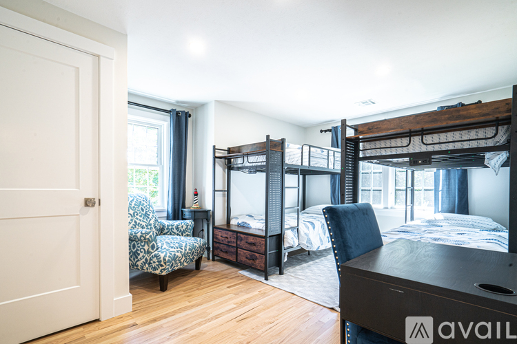 A bedroom with a bunk bed and a chair.