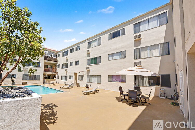 A sunny day at the poolside of a multi-story apartment building.