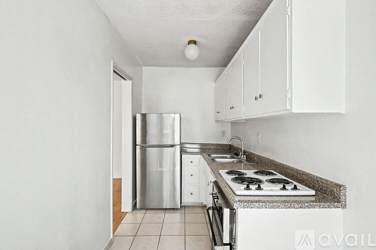 A kitchen with white cabinets and a granite countertop.
