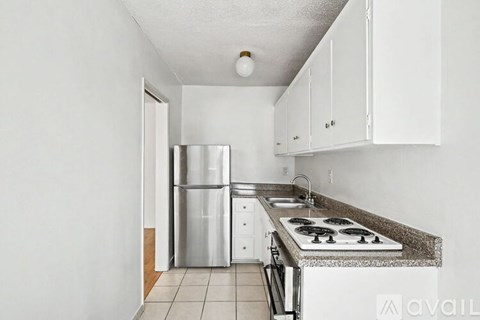 A kitchen with white cabinets and a granite countertop.