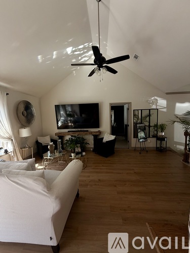 A living room with a white couch and a television.