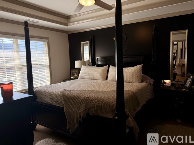 A bedroom with a bed, nightstand, and window.