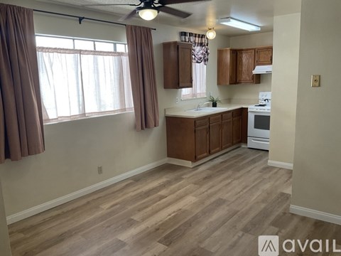 A kitchen with wooden cabinets and a ceiling fan.