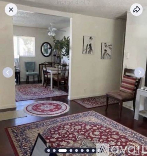 A room with a rug on the floor and a chair.