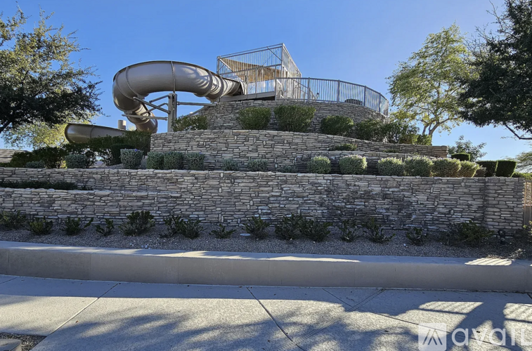 A playground with a slide and a wall.