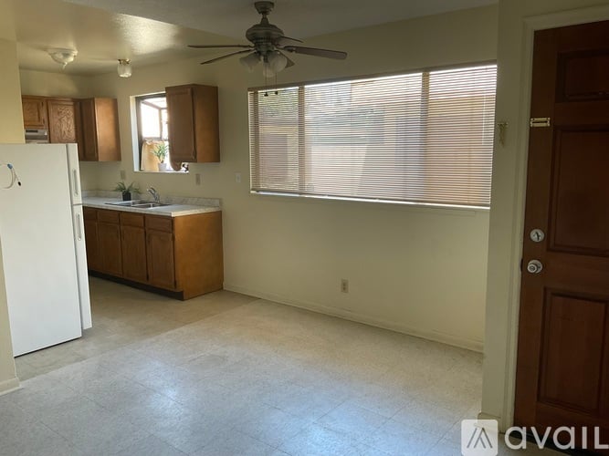 A kitchen with a refrigerator, sink, and cabinets.