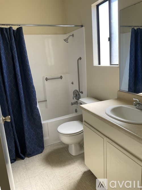 A bathroom with a toilet, sink, and shower.