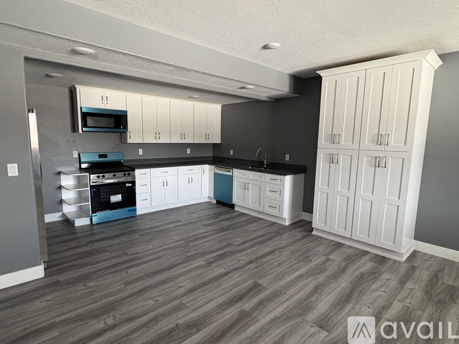 A kitchen with white cabinets and a black countertop.