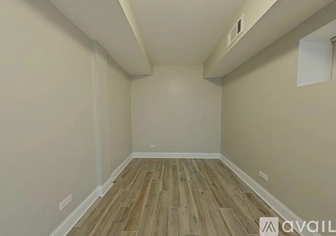 A room with wooden flooring and white walls.