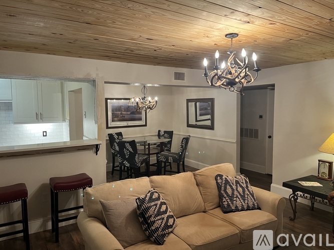 A living room with a couch, chairs, and a dining table.