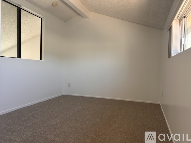 A room with a carpeted floor and a window.