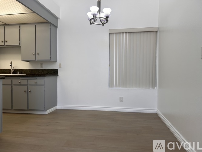 A kitchen with a sink and a window with blinds.