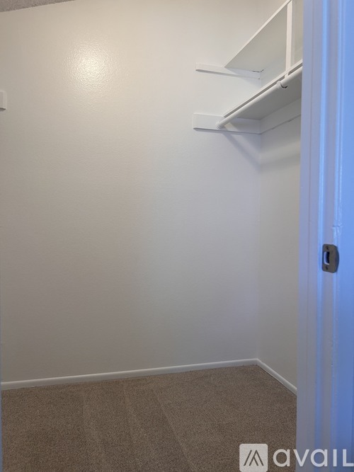 A room with a door and a carpeted floor.