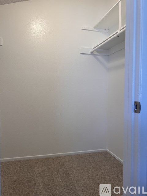 A room with a door and a carpeted floor.