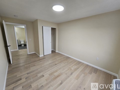 A room with wooden flooring and a white ceiling light.