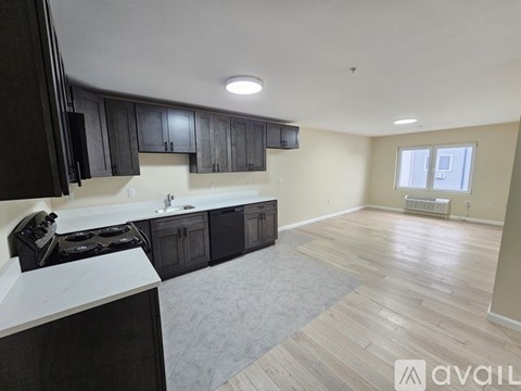A kitchen with black cabinets and a white countertop is available.