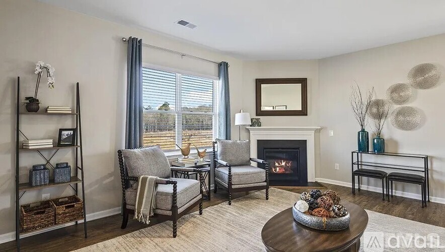 A living room with a fireplace and a large window.