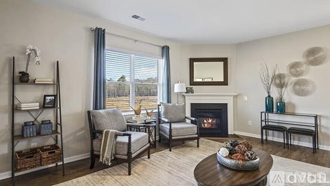 A living room with a fireplace and a large window.