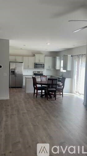 A kitchen with a dining table and chairs.