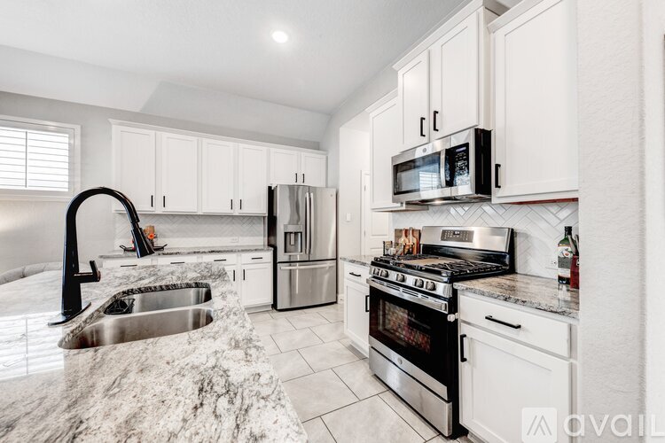 A kitchen with white cabinets and stainless steel appliances.