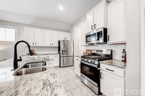 A kitchen with white cabinets and stainless steel appliances.