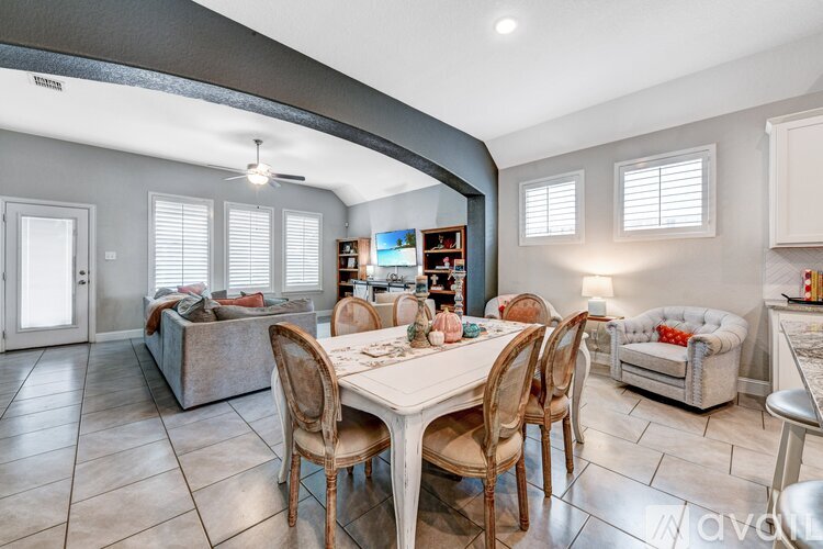 A living room with a white dining table and chairs.